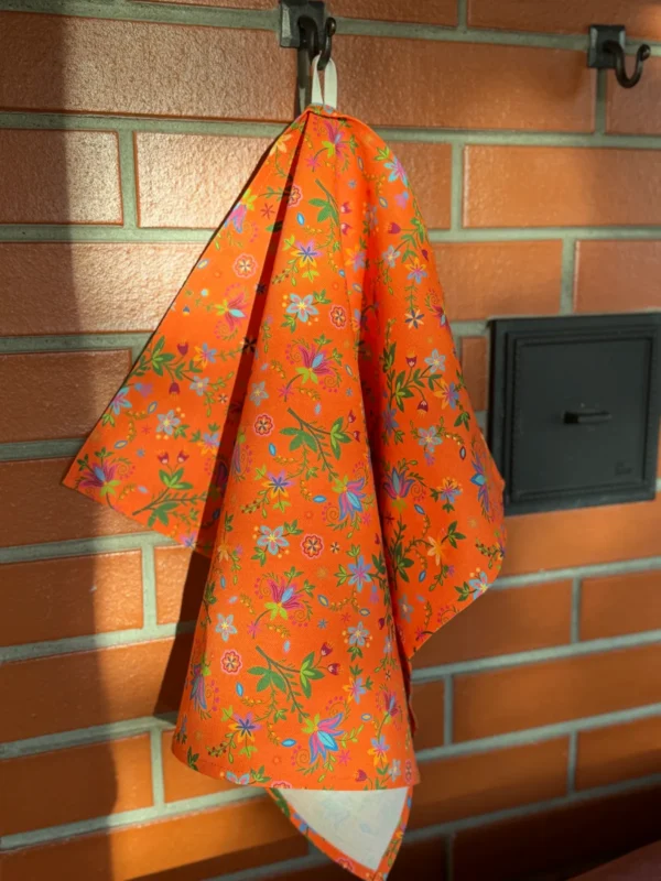 oranž lillelise mustriga Eestis disainitud ja valmistatud köögirätik riputusaasaga