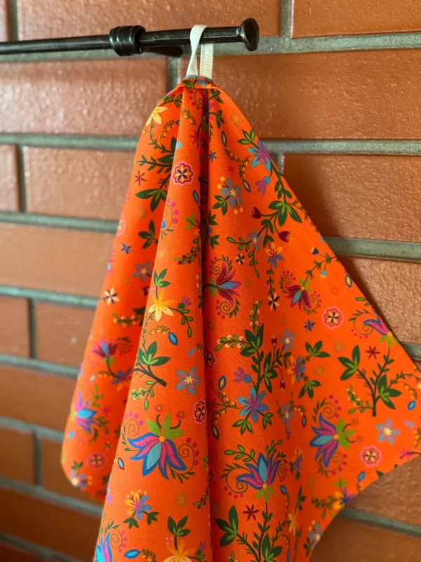 oranž lillelise mustriga Eestis disainitud ja valmistatud köögirätik riputusaasaga